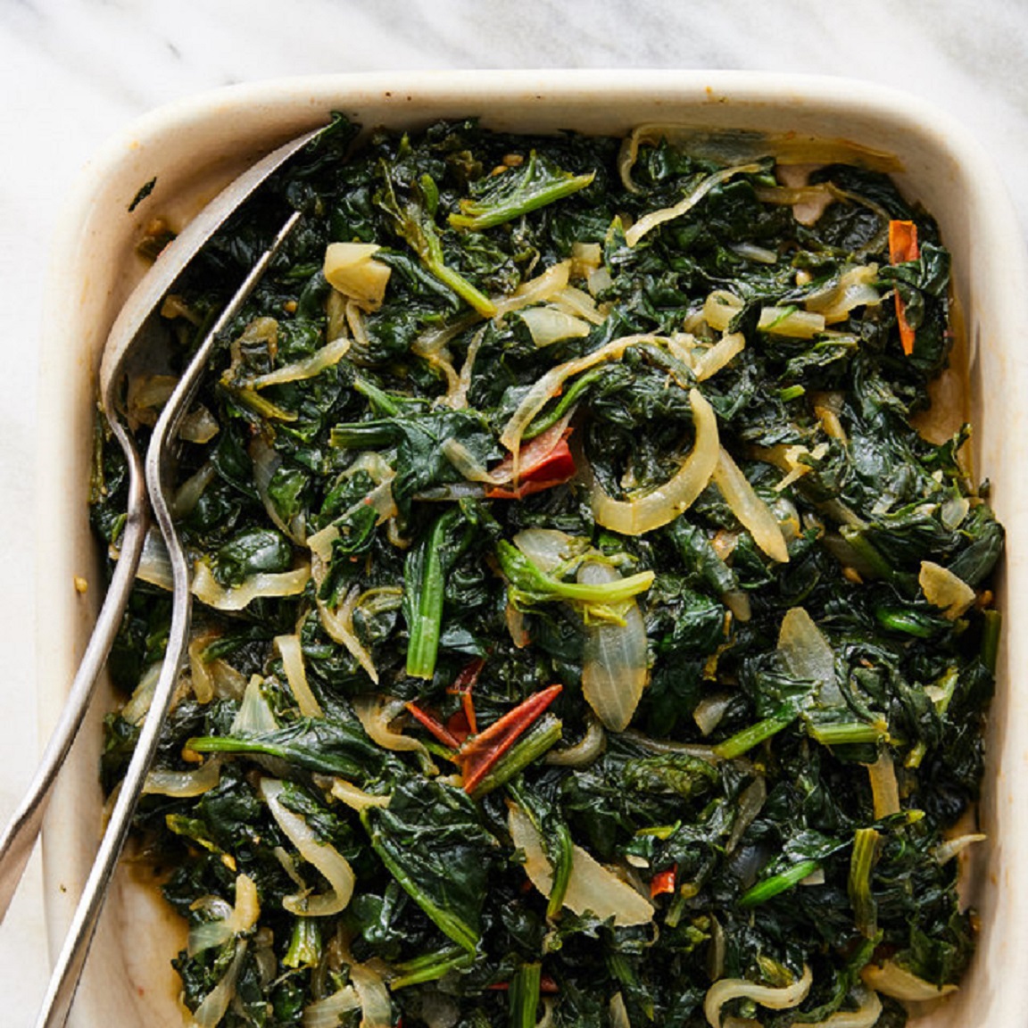 <p> Callaloo is a leafy green vegetable dish often compared to spinach. It’s typically cooked with onions, garlic, tomatoes, and Scotch bonnet peppers for a bit of heat. Sometimes, it's mixed with saltfish, or other meats for added flavor. This nutritious dish is commonly served as a side with breakfast or dinner and is a staple in many Jamaican households. </p> :: NYT