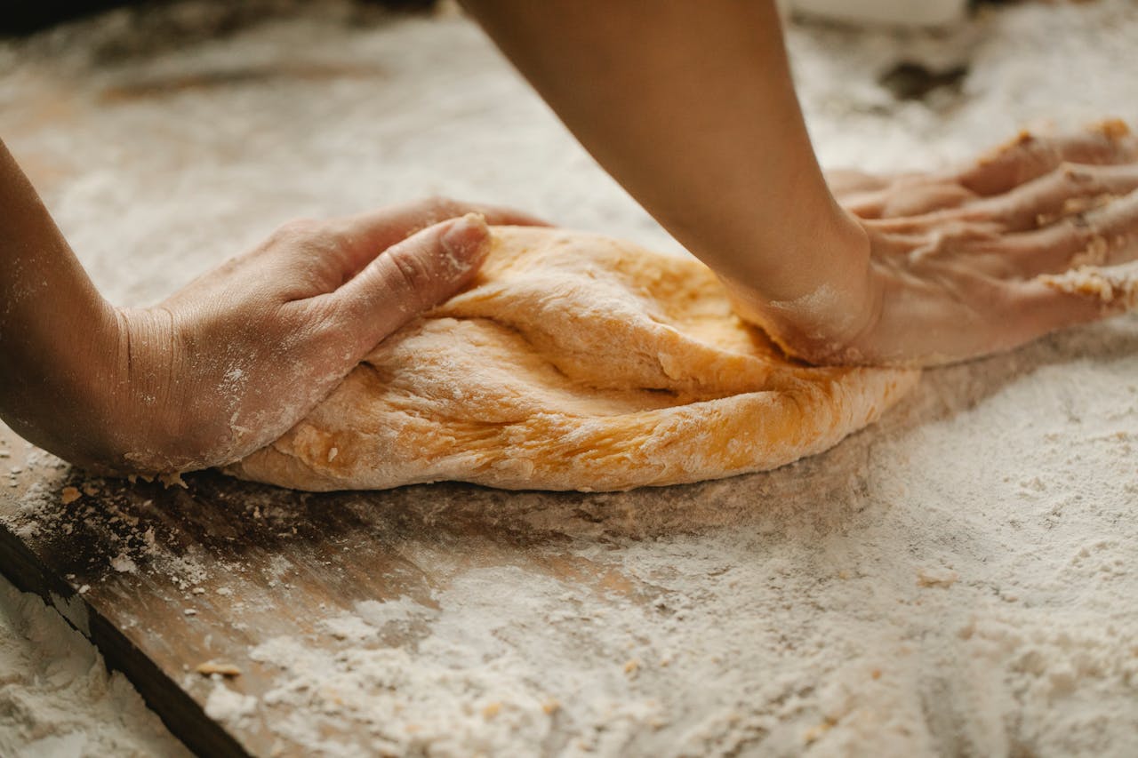 <p> Kneading helps develop the gluten in the dough, which gives your bread structure and chewiness. However, over-kneading can make your bread tough. The goal is to knead just enough to get the dough smooth and elastic. A good trick is to perform the "windowpane test." Take a small piece of dough and stretch it between your fingers. If it forms a thin, translucent window without tearing, your dough is ready. If it tears, continue kneading for a few more minutes. </p> :: Pexels