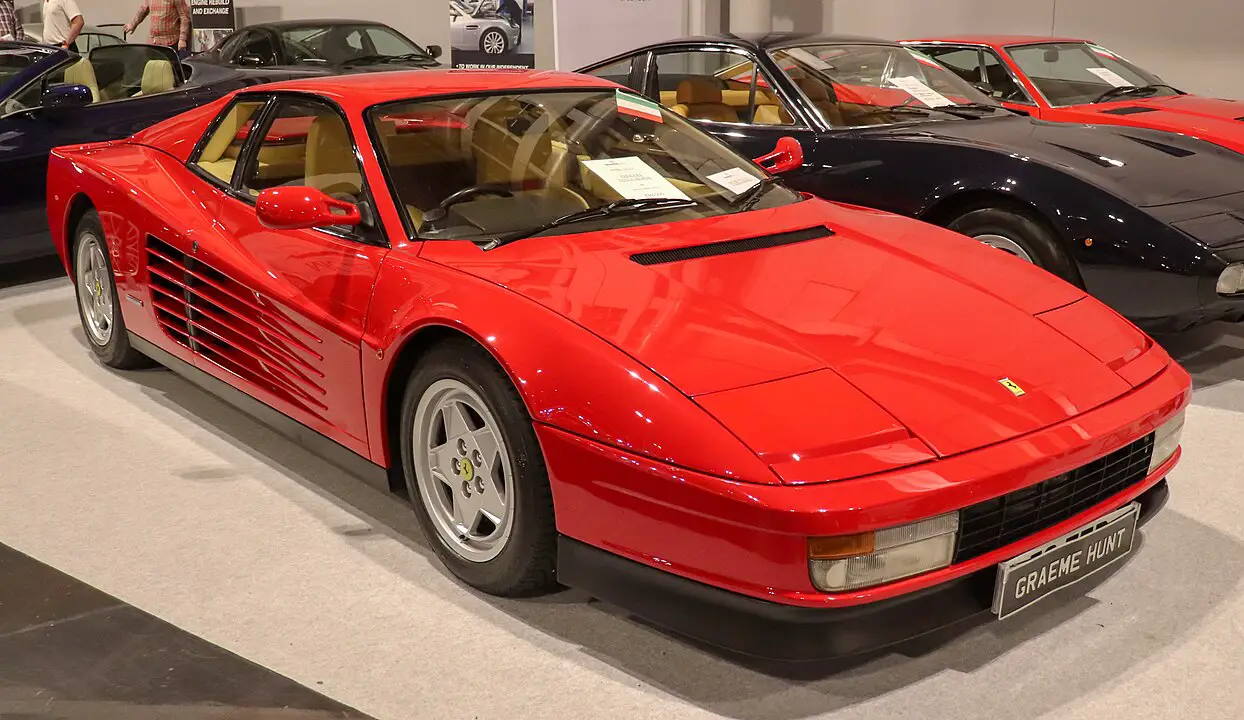 <p>The Testarossa’s name translates to “redhead” in Italian, referring to the car’s red-painted cam covers. It was also one of the few Ferraris to feature the “flat-12” engine, adding to its unique allure. The car’s wide rear track and bold side strakes were designed to improve stability and cooling.</p> ::Vauxford