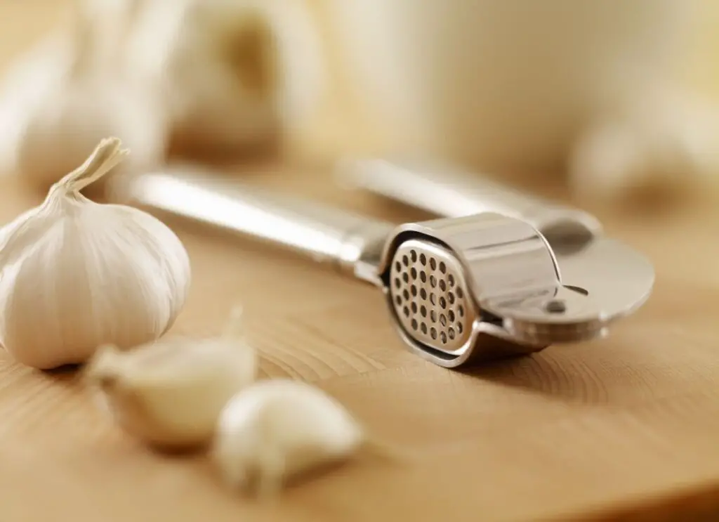 <p> If you cook with garlic often, a garlic press will make your life so much easier. Instead of chopping or mincing garlic by hand, a garlic press allows you to crush the cloves effortlessly, releasing all the aromatic oils and flavors without the hassle of peeling. This gadget is particularly useful when you need a lot of garlic for your dishes, like when preparing sauces, soups, or marinades. The minced garlic from a press is more uniform than manually chopped garlic, ensuring that the flavor is evenly distributed in your dish. A garlic press is small, easy to use, and helps you save time and effort when cooking with this flavorful ingredient. </p> :: Adam Gault/Getty